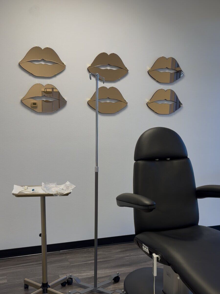 The Blanqa Medspa treatment room, with its six gold lip-shaped mirrors on the wall.